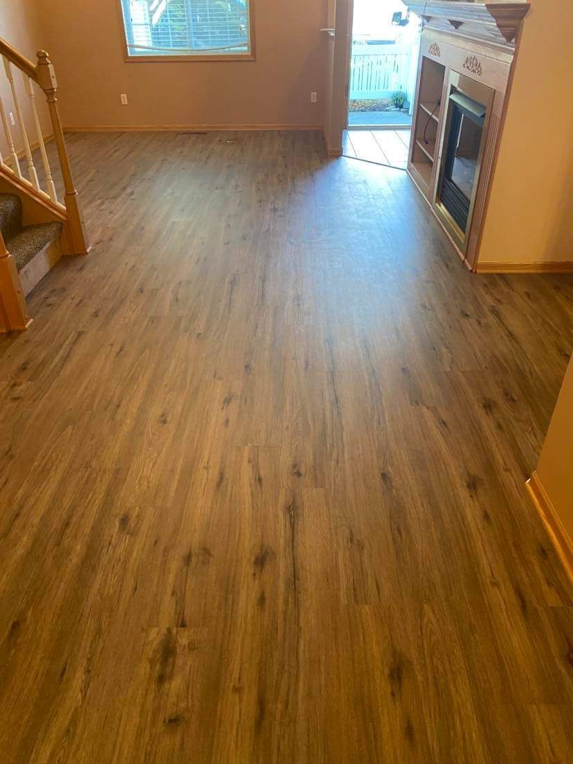 Living room with medium brown plank LVP flooring installed throughout the space.