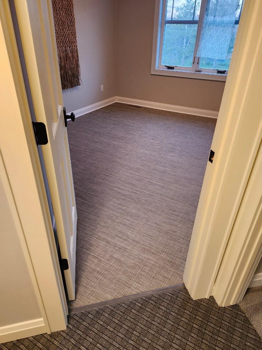 Bedroom with gray LVP flooring in plank pattern installed wall-to-wall.