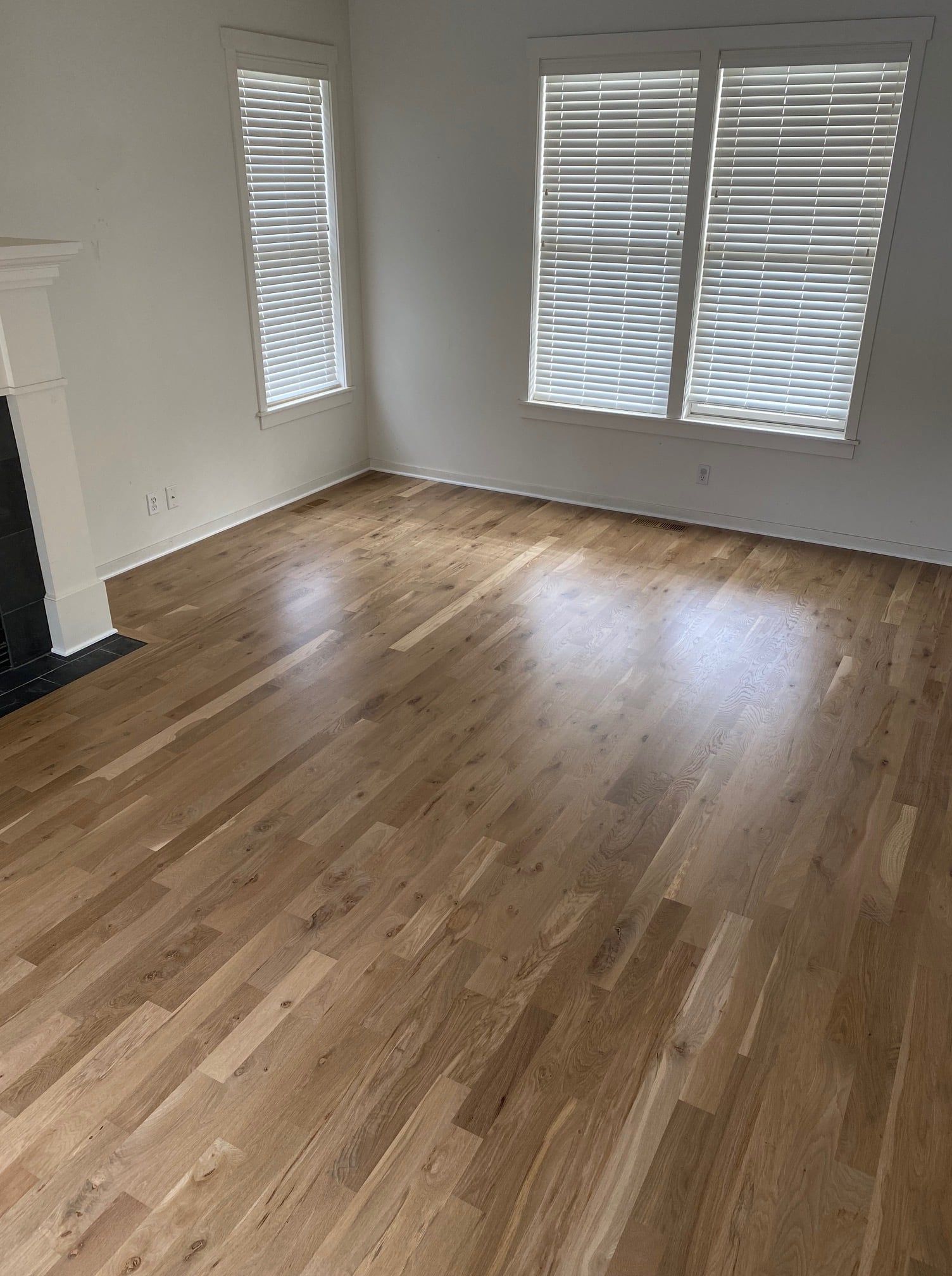 Newly refinished white oak hardwood floor in bedroom with plank pattern and natural wood tones.
