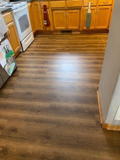Kitchen with medium brown wood-grain LVP flooring in plank pattern installed throughout.