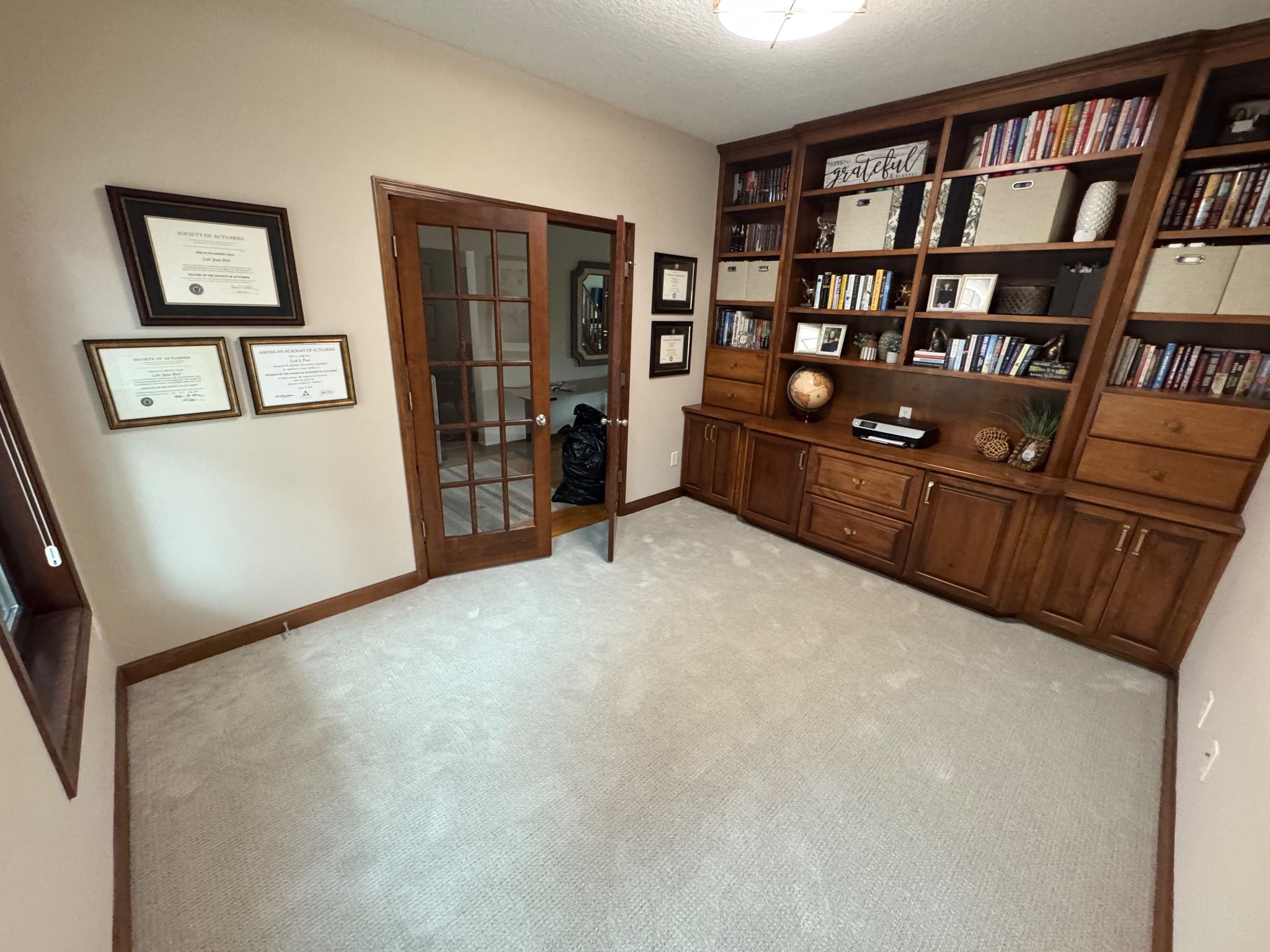 Light beige carpet installed wall-to-wall in a bedroom with wood trim and built-in shelving.