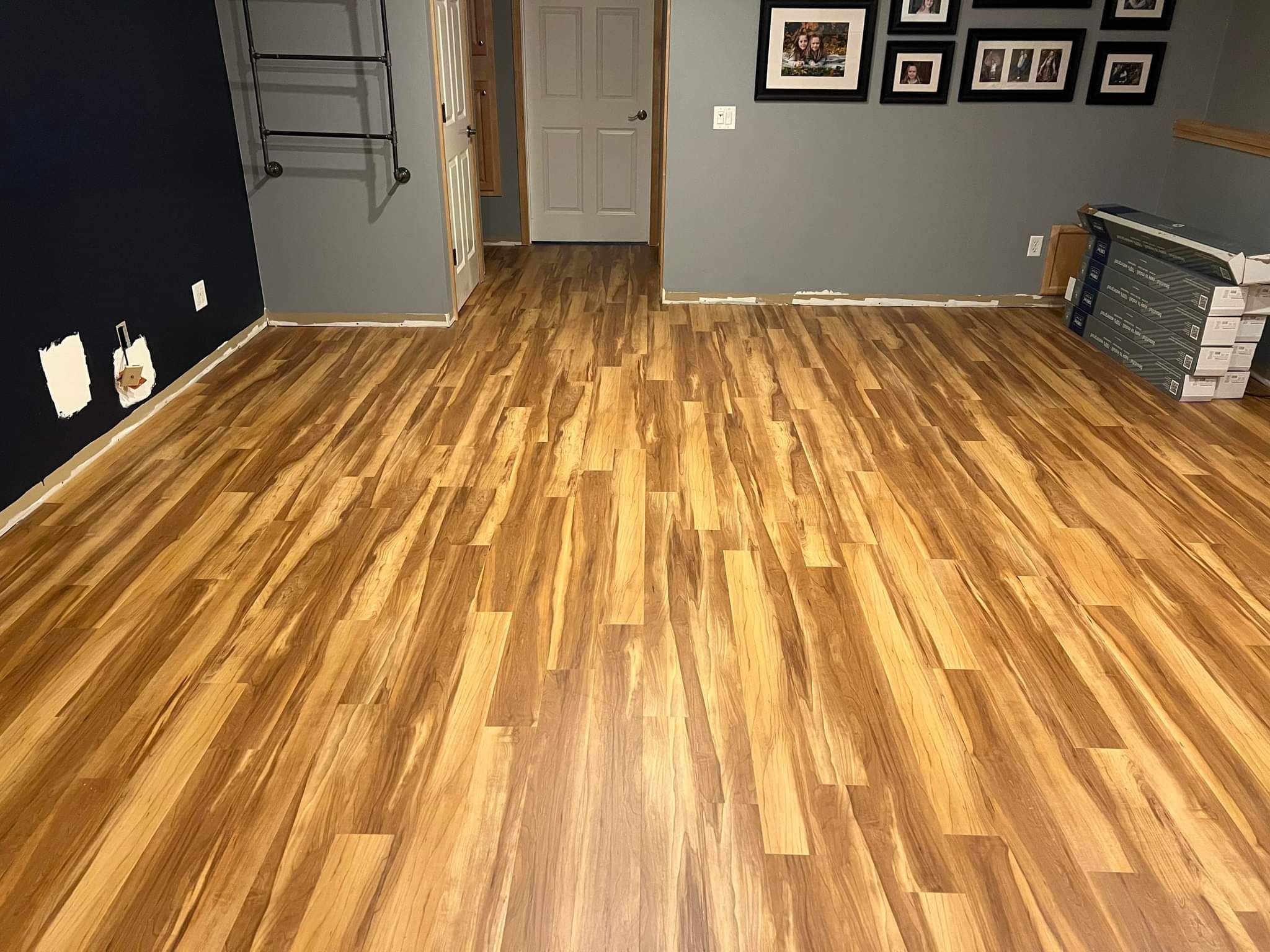 Bedroom with medium-toned luxury vinyl plank flooring in varied warm wood tones.