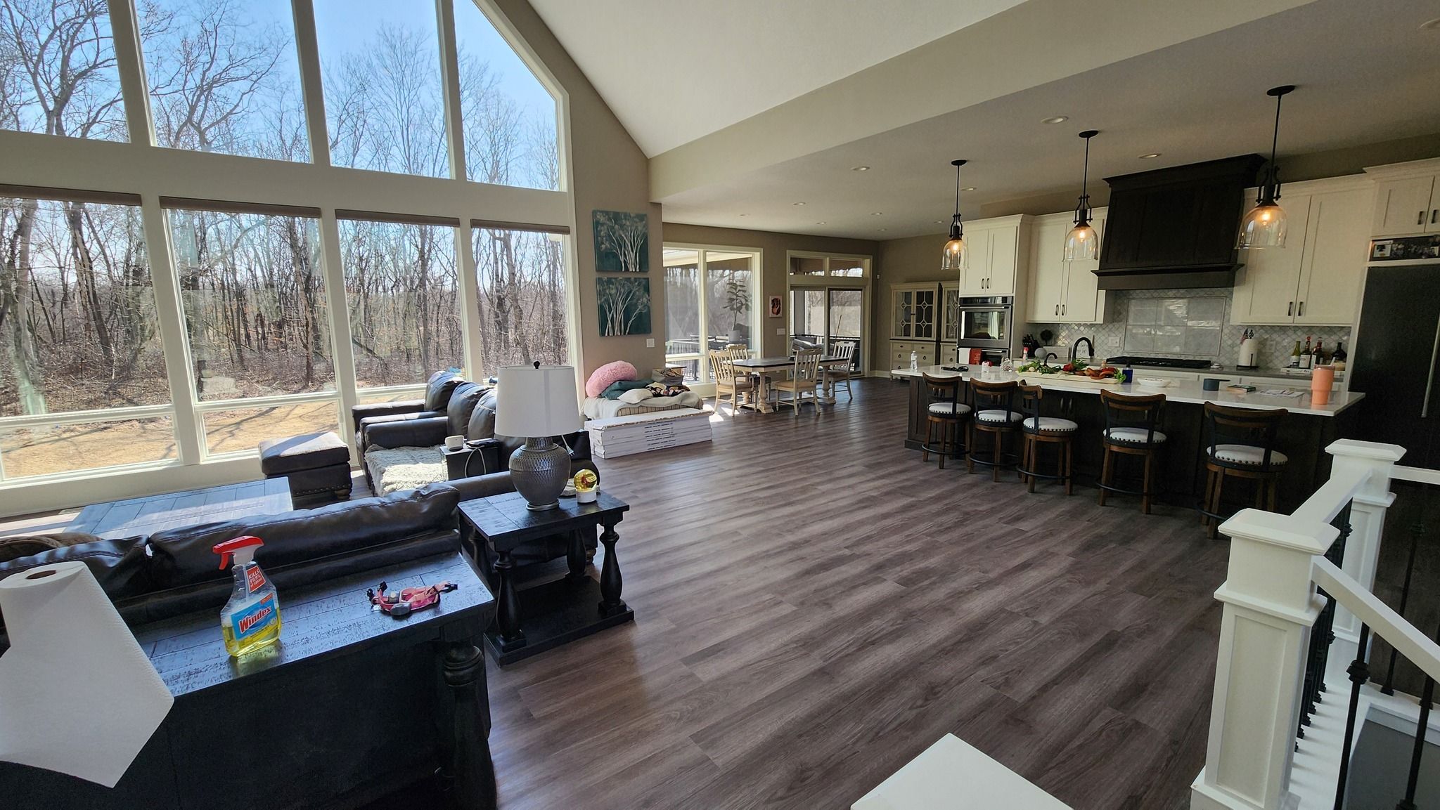 Open concept living room and kitchen with luxury vinyl plank flooring in brown and gray tones.