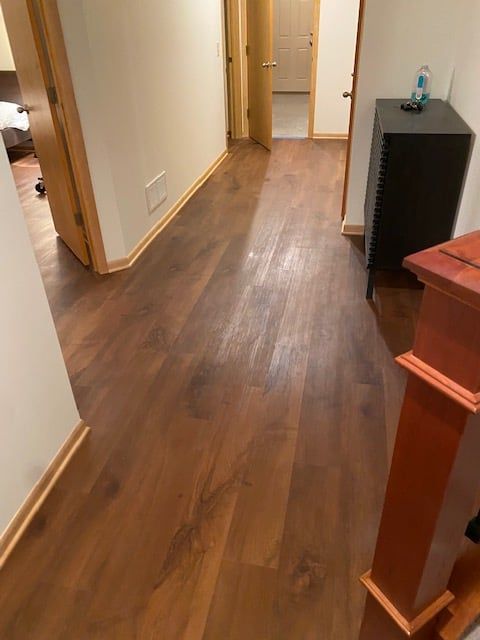 Hallway with medium brown wood-grain LVP flooring and white walls.