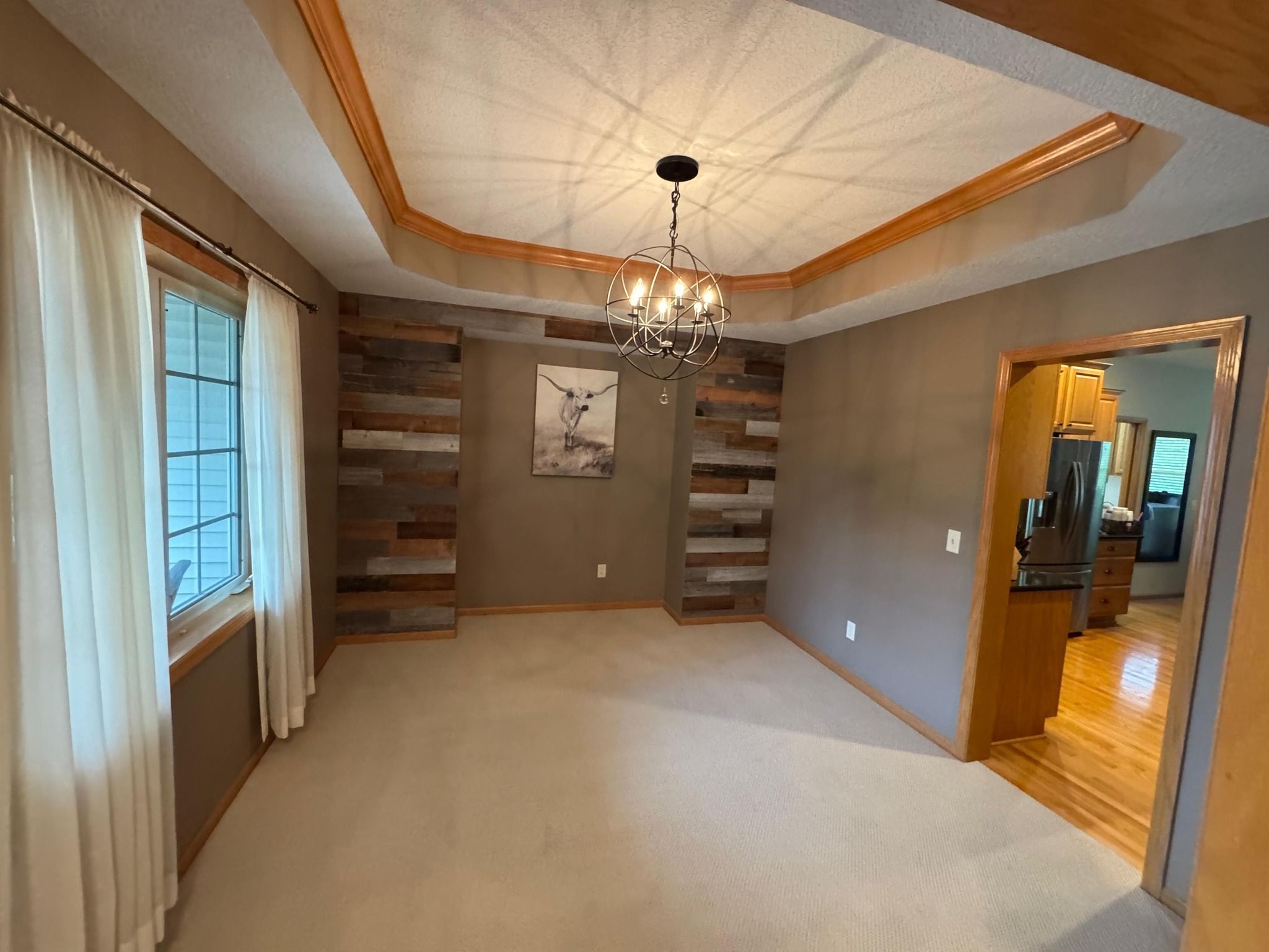 Light beige carpet installed in a living room with coffered ceiling and wood beam trim.
