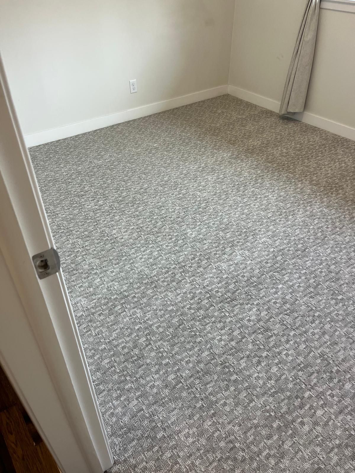 Gray textured carpet installed in a bedroom with white walls and trim.