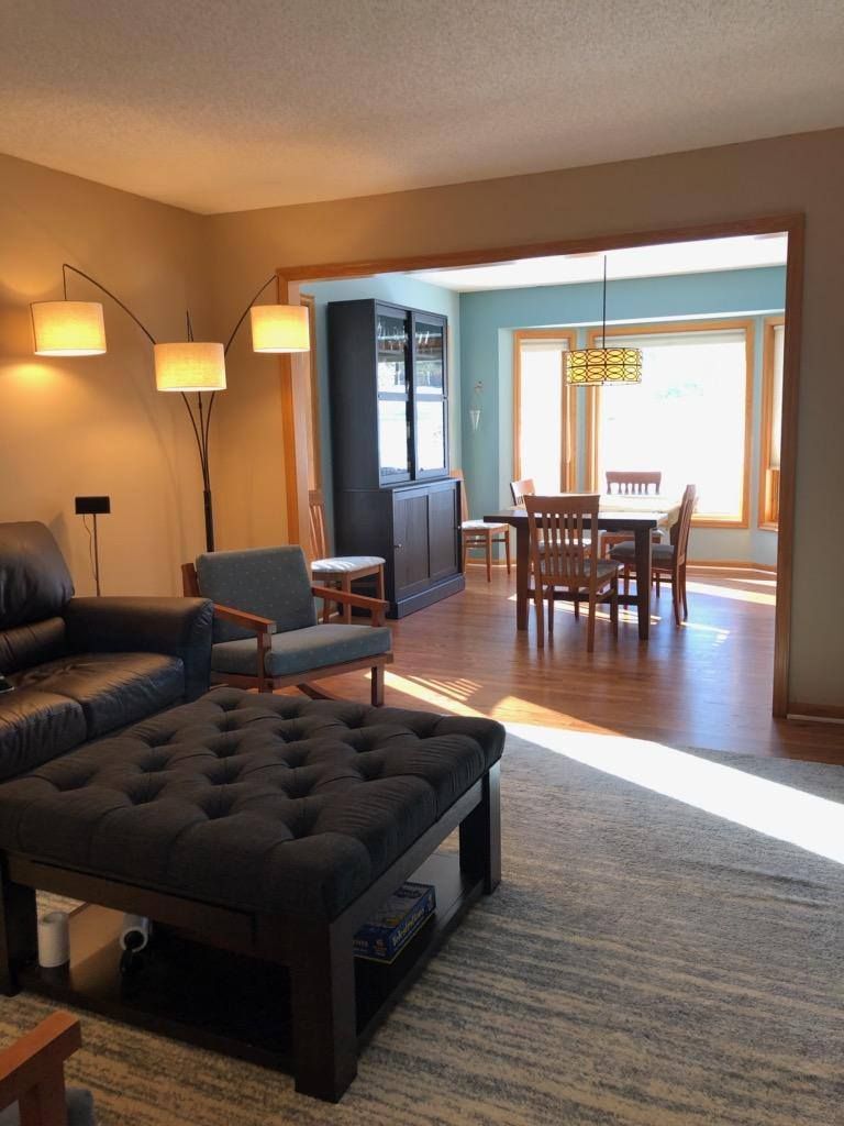 Living room with medium-tone hardwood floors and open sightlines to dining area beyond.