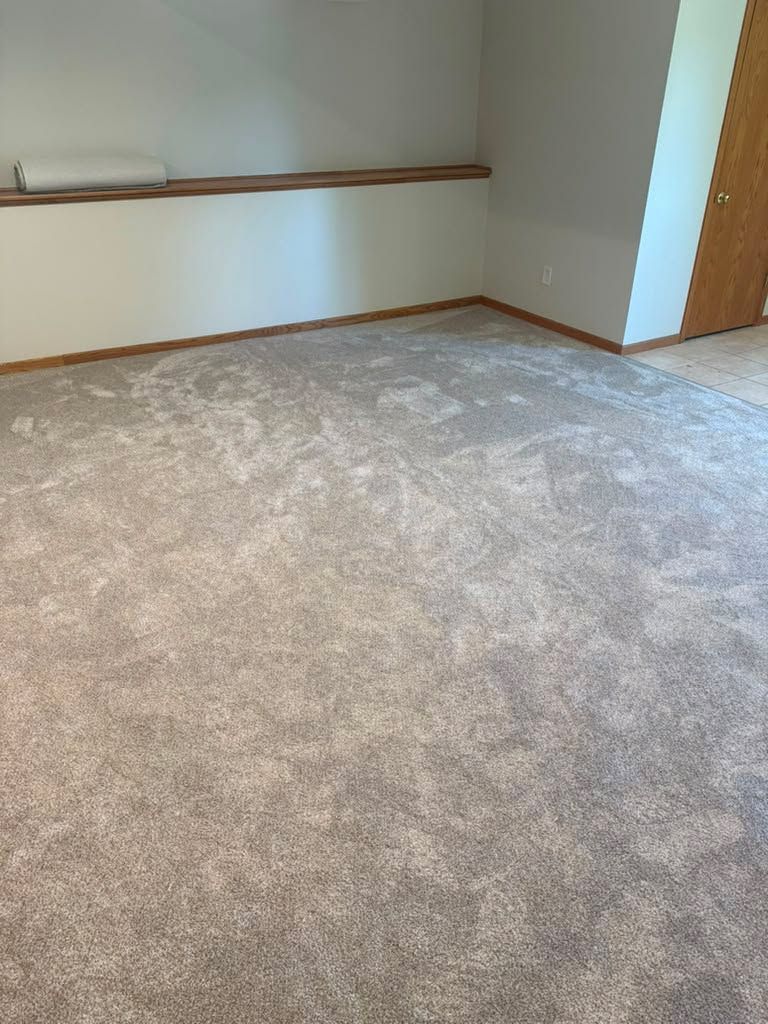 New gray carpet installed in an empty bedroom with white walls and wood trim.