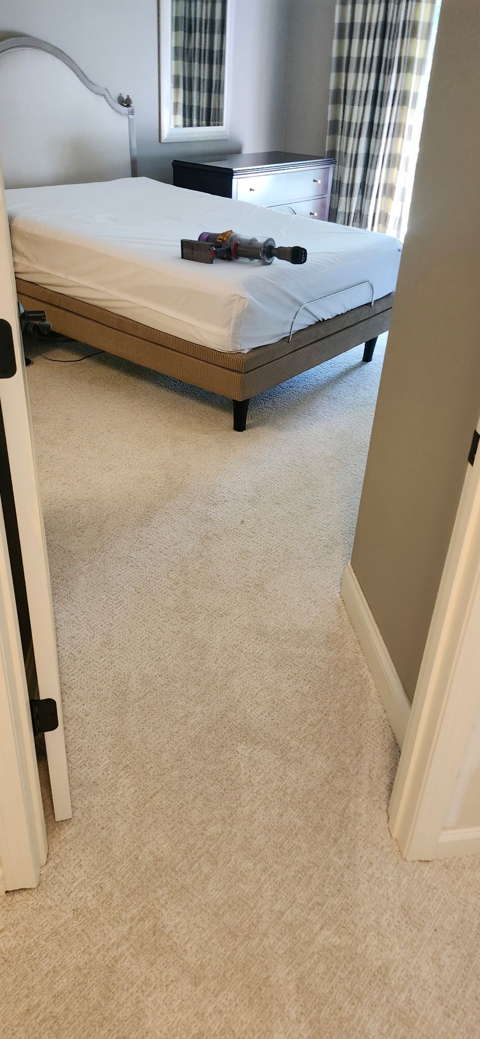 Beige carpet installed in a bedroom with a bed and nightstands visible.