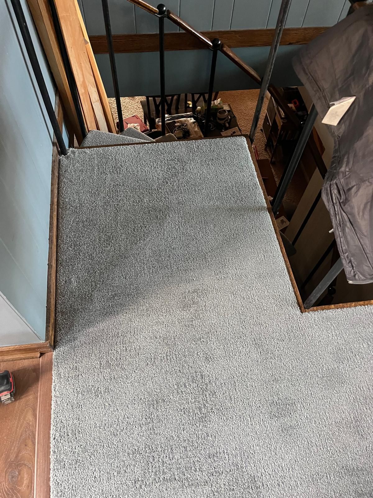 Light gray carpet installed on stairs with wooden frame and metal railings.
