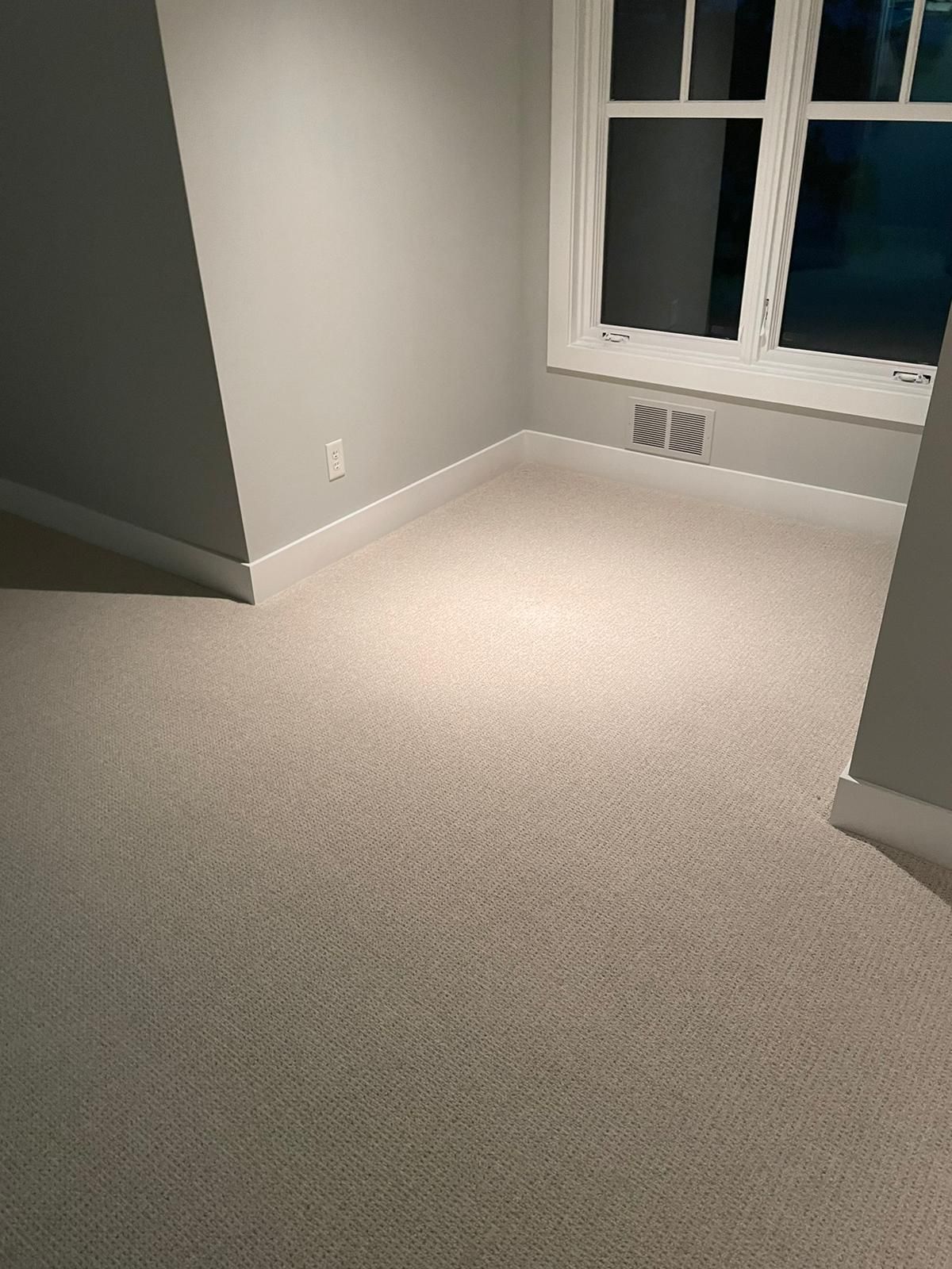 Light beige wool carpet installed in a bedroom with gray walls and white trim.