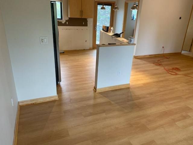 Light tan and brown plank LVP flooring installed in an open kitchen and living area with white island.