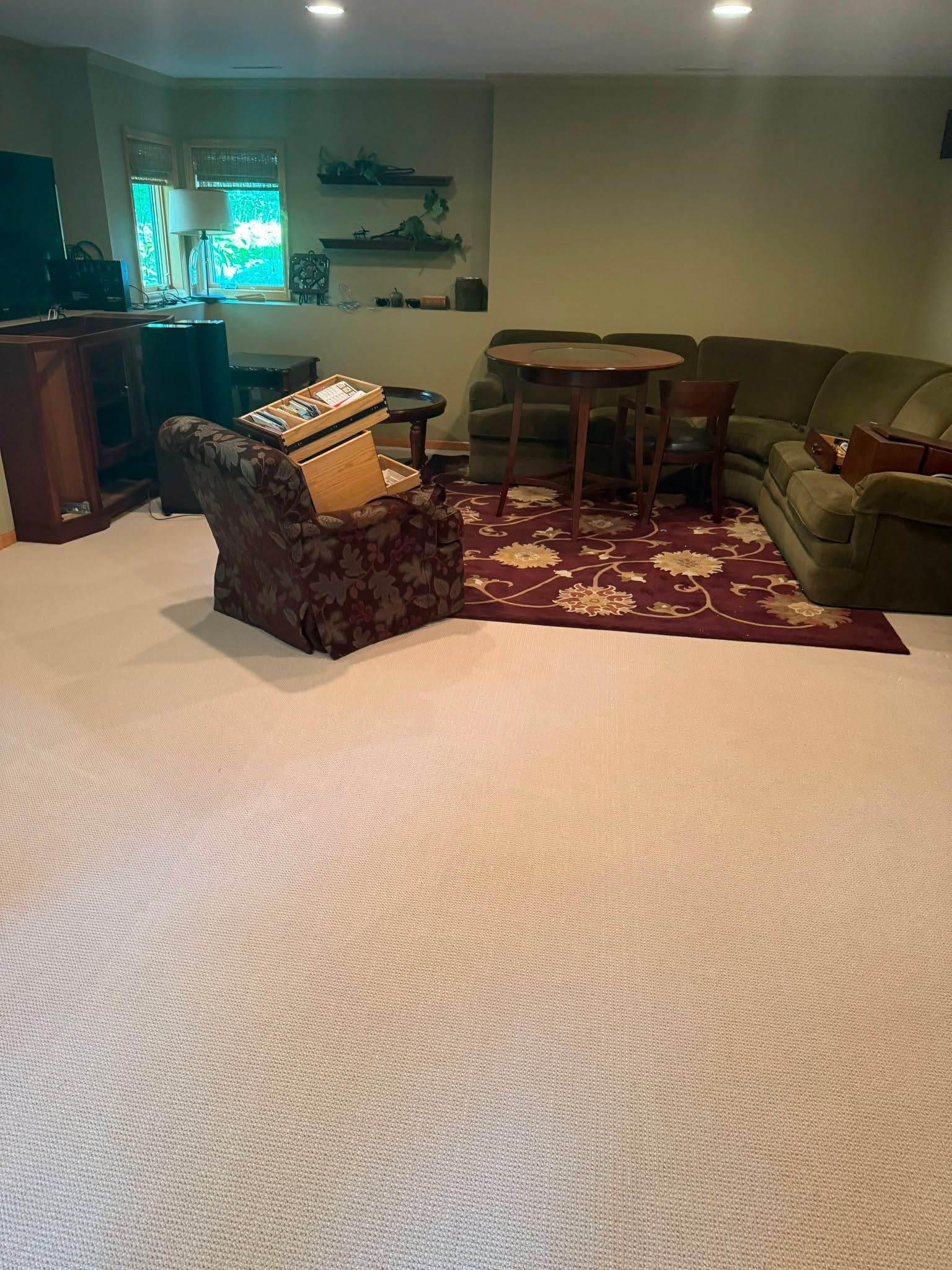 Beige carpet installed in a basement living area with furniture and a decorative area rug.