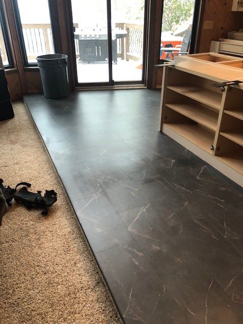 Dark plank LVP with marble veining installed in kitchen during remodel.