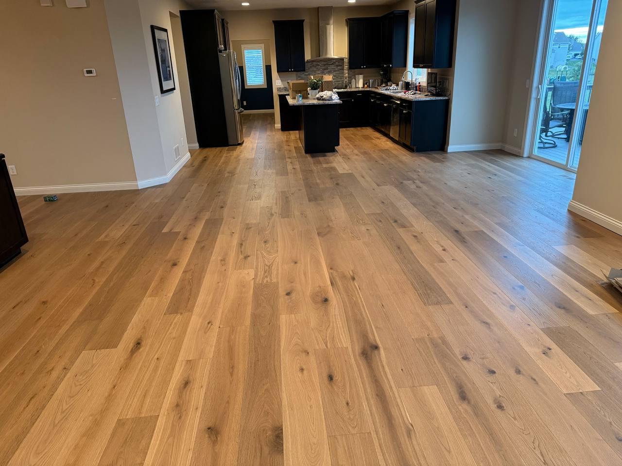 Wide-plank engineered hardwood through an open kitchen, installed by Anton's Floorcovering
