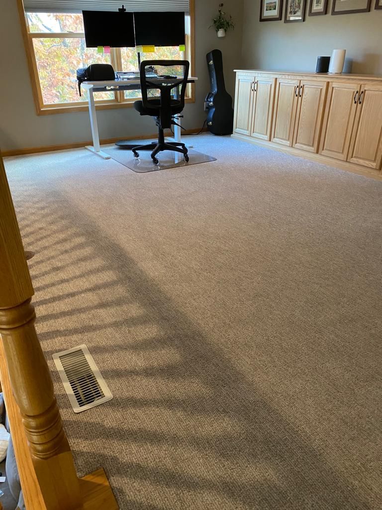 Light beige textured carpet installed in a bedroom with wooden baseboards and cabinetry.