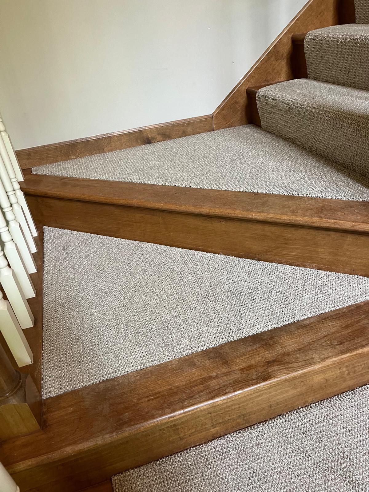 Beige textured carpet installed on stairs with wood nosing and treads.