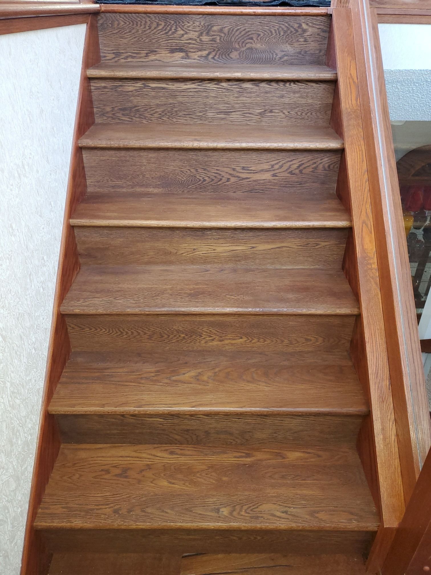 Hardwood stair treads with brown finish and visible wood grain patterns.