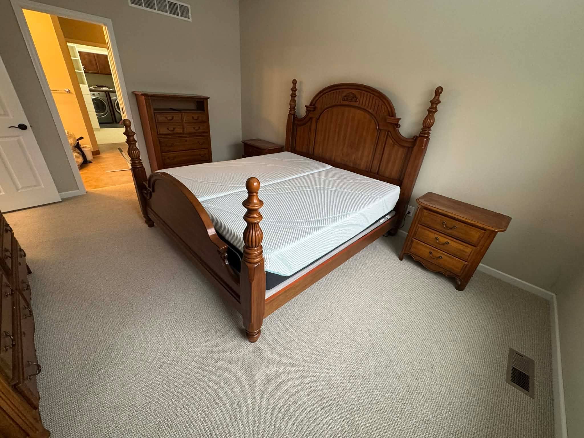 Beige textured carpet installed in a bedroom with wooden furniture.